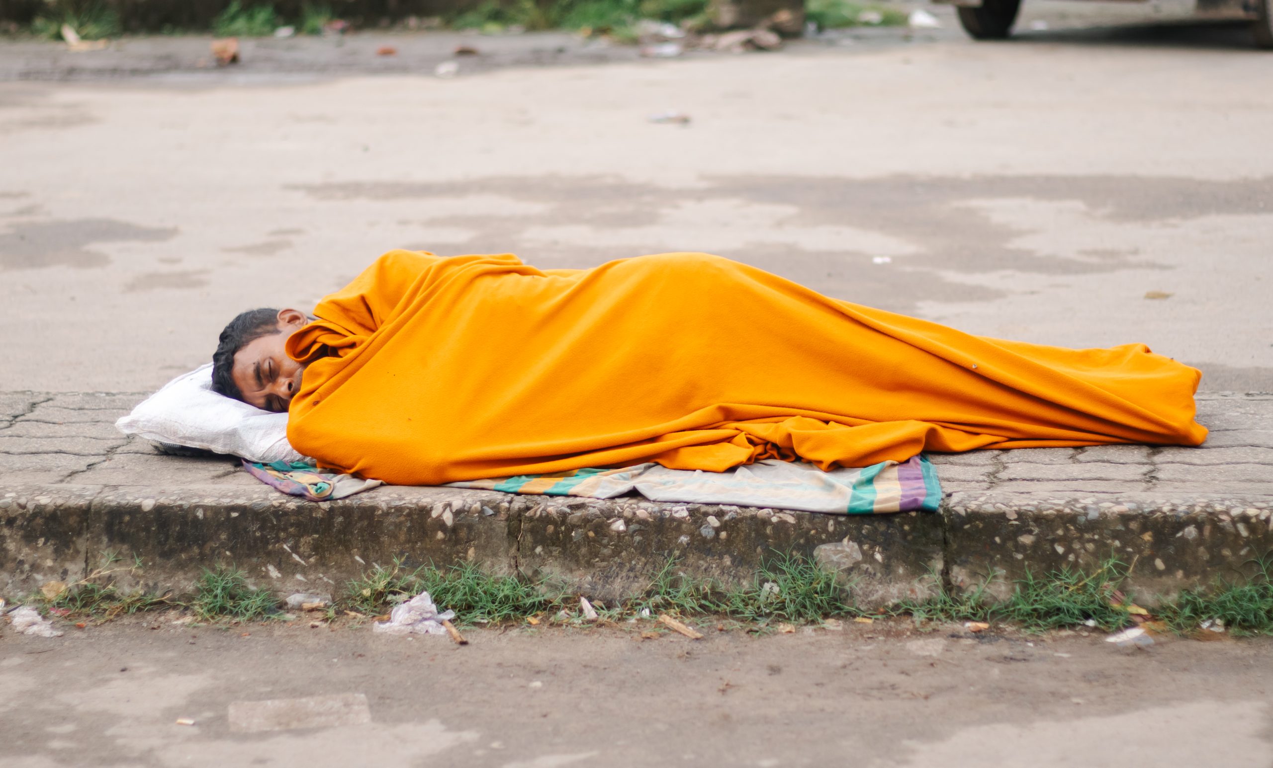 A homeless person is sleeping on the street.